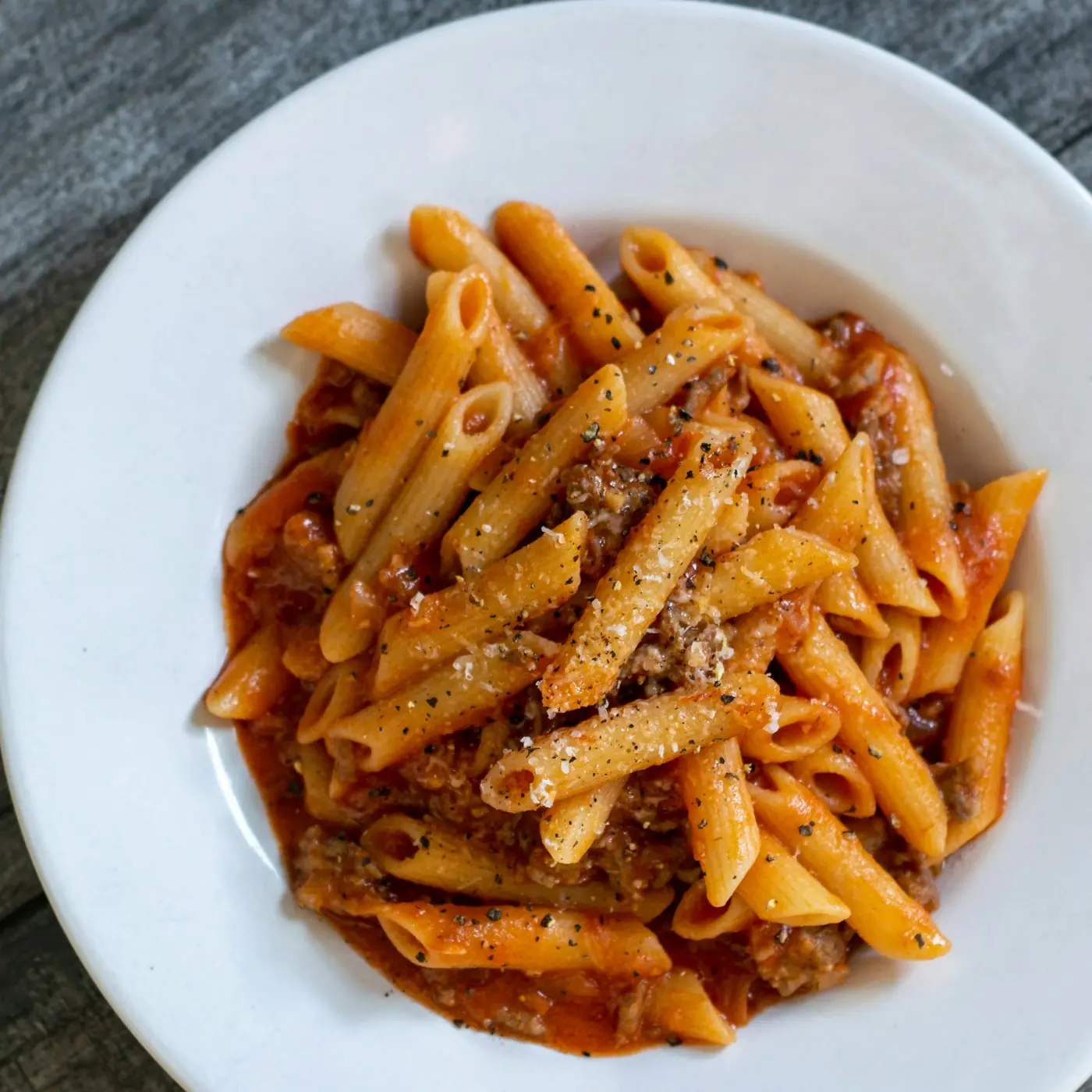 Penne pasta in a rich ground beef tomato sauce with parmesan